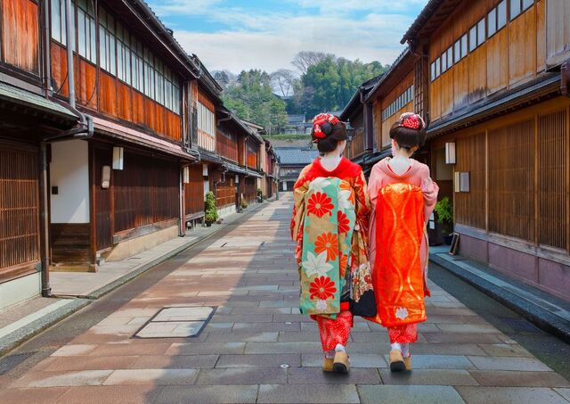 Deux geishas de dos marchant dans une rue du quartier historique d’Higashi Chaya à Kanazawa, Japon 