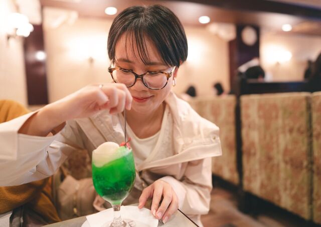 Jeune femme dégustant un cream soda dans un kissaten rétro au Japon