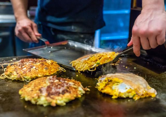 Okonomiyaki en train de cuire sur une plaque chaude